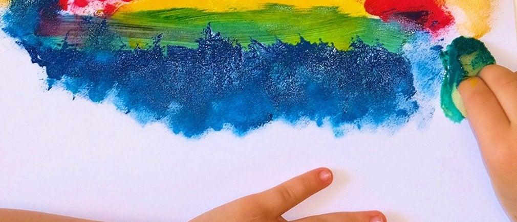 Éponge tampon et mains d’enfant réalisent une peinture