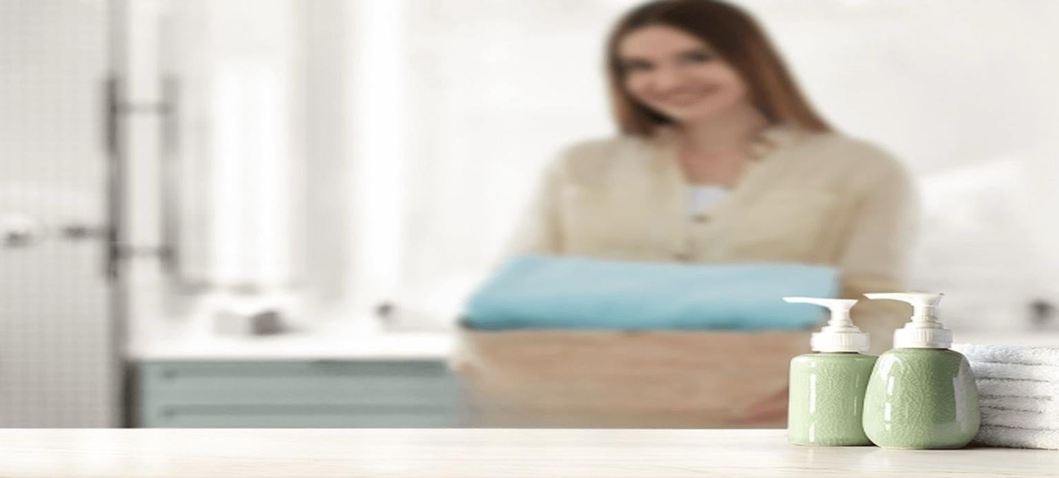 Flacons de shampoing vert sur fond flou avec une femme