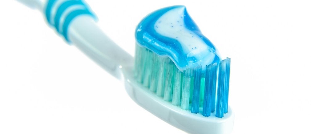 Une brosse à dents recouverte de dentifrice bleu