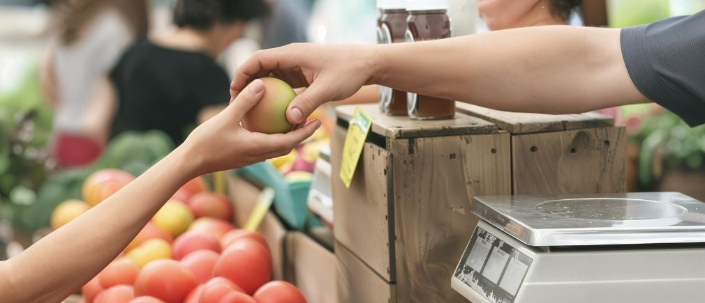 Achat d’une pomme sur un étal de marché