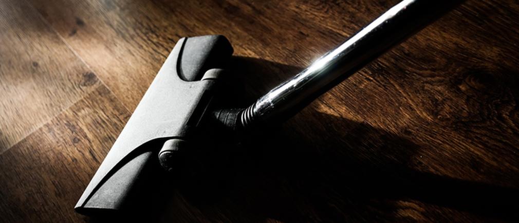 Tête d’aspirateur posée sur un parquet en bois