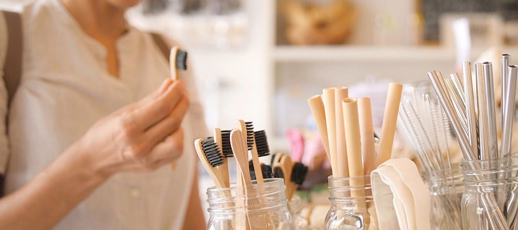 Main d’un client tenant une brosse à dents en bambou en boutique