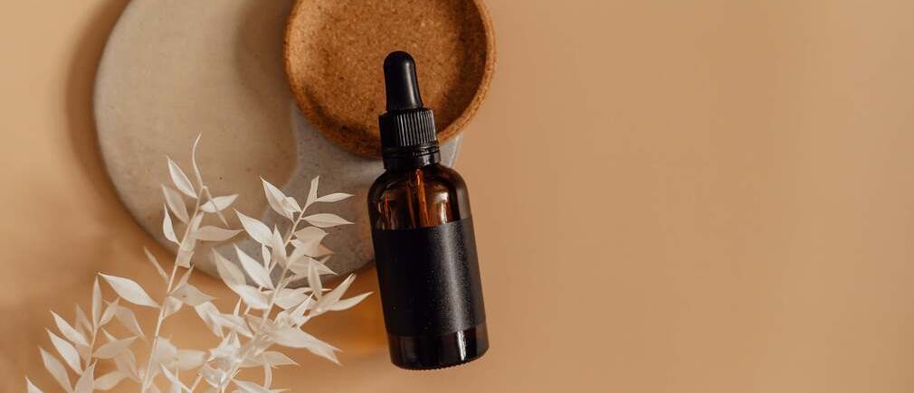 Flacon d’huile essentielle posé sur un plateau de bain