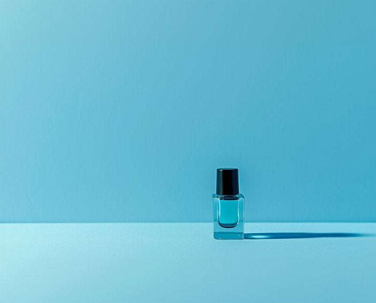 Flacon de vernis à ongles bleu sur fond uni