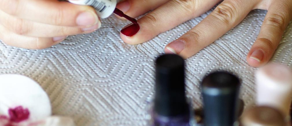 Application de vernis rouge sur les ongles