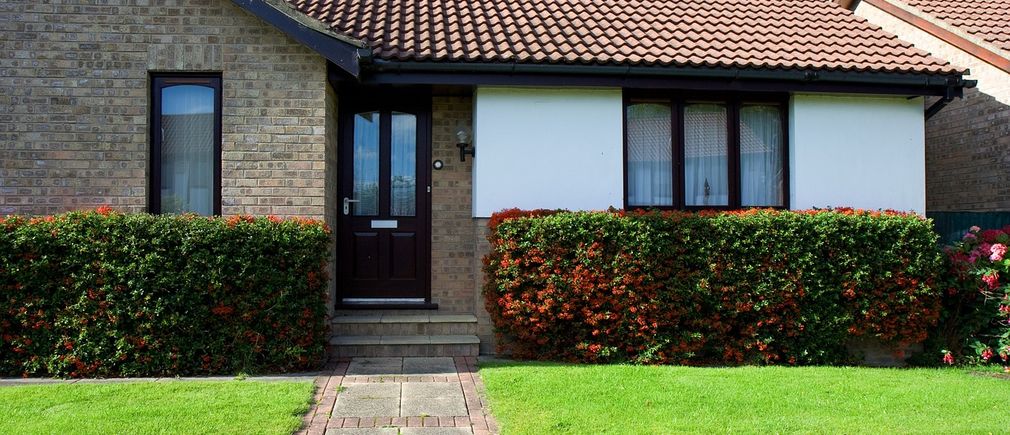 Maison avec haies fleuries devant l’entrée