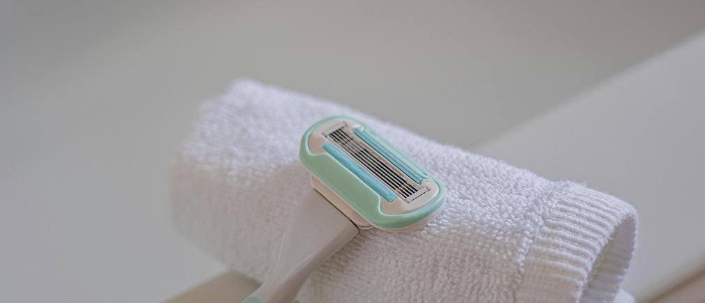 Cartouche de rasoir jetable verte posée sur une serviette blanche