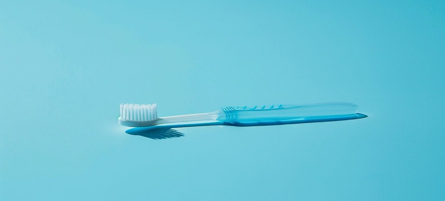 Brosse à dents en plastique posée sur un fond bleu