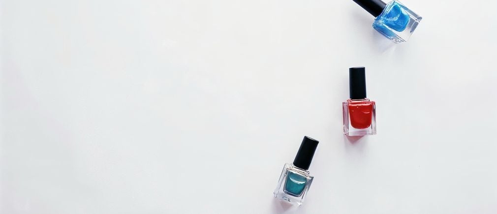 Trois flacons de vernis à ongles sur fond blanc